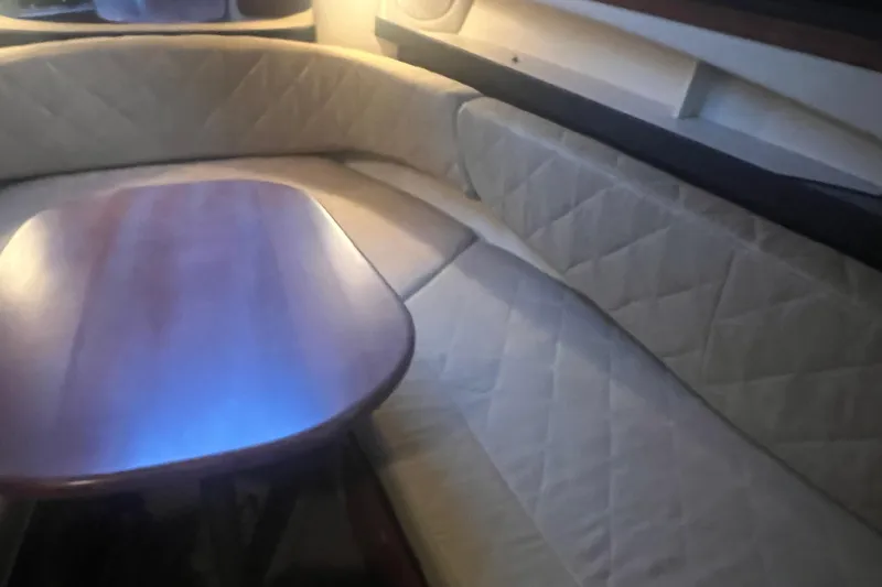 Slide: The Image of Interior of 2007 Sea Ray 260 Sundancer with cushioned seating and wooden table. - 15