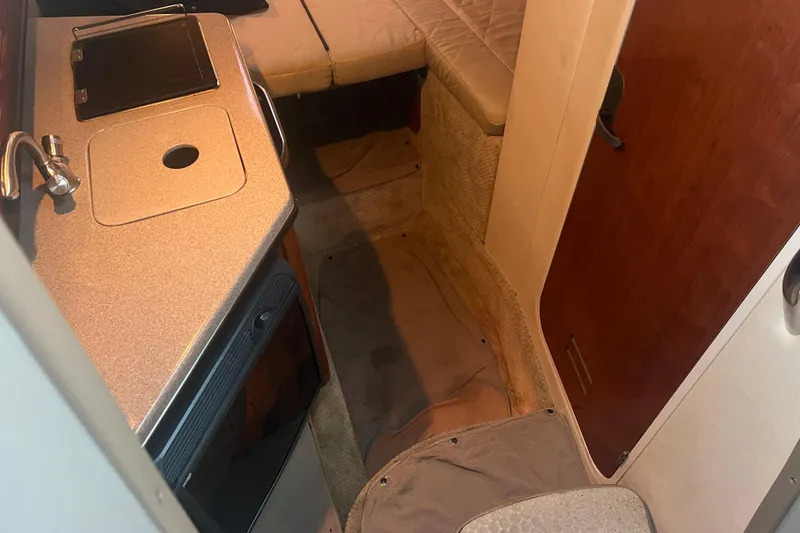 Slide: The Image of Interior of 2007 Sea Ray 260 Sundancer boat with kitchenette and seating area. - 21