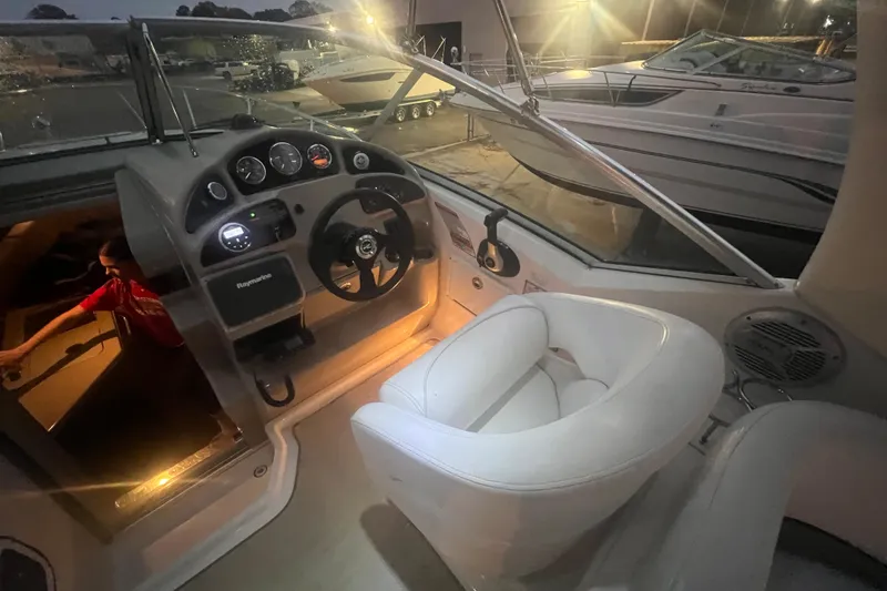 Slide: The Image of 2007 Sea Ray 260 Sundancer cockpit with illuminated dashboard and white captain's chair. - 36