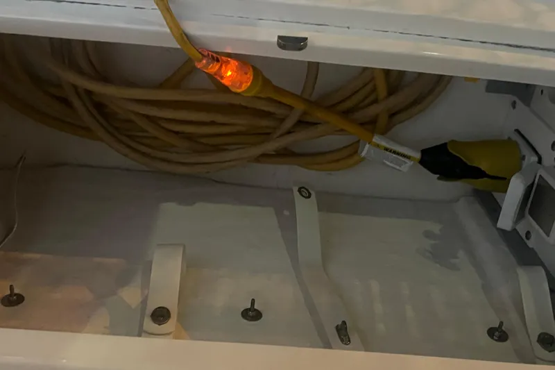 Slide: The Image of Storage compartment with coiled yellow cable in a 2007 Sea Ray 260 Sundancer boat. - 44