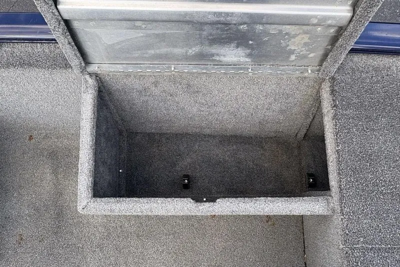Slide: The Image of 2019 Tracker Pro 170 boat storage compartment, open and empty, with gray carpet lining. - 24