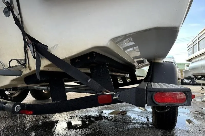 Slide: The Image of 2018 Tahoe 215 Xi boat on trailer, rear view with straps and wet pavement. - 10