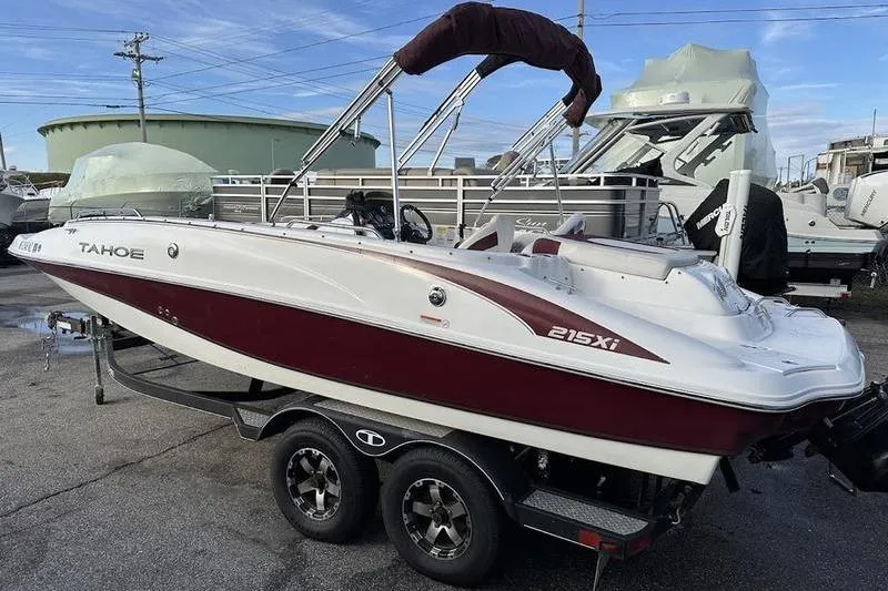Slide: The Image of 2018 Tahoe 215 Xi boat on trailer, parked outdoors. - 16