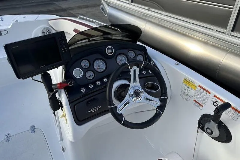 Slide: The Image of 2018 Tahoe 215 Xi boat dashboard with steering wheel and control panel. - 17
