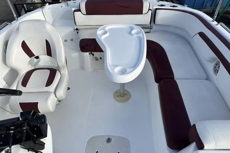 Slide: The Image of 2018 Tahoe 215 Xi boat interior with white and maroon seating and a central table. - 18