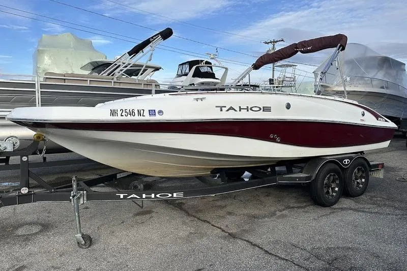 The Image of 2018 Tahoe 215 Xi boat on trailer, parked at marina, clear sky background. - 2