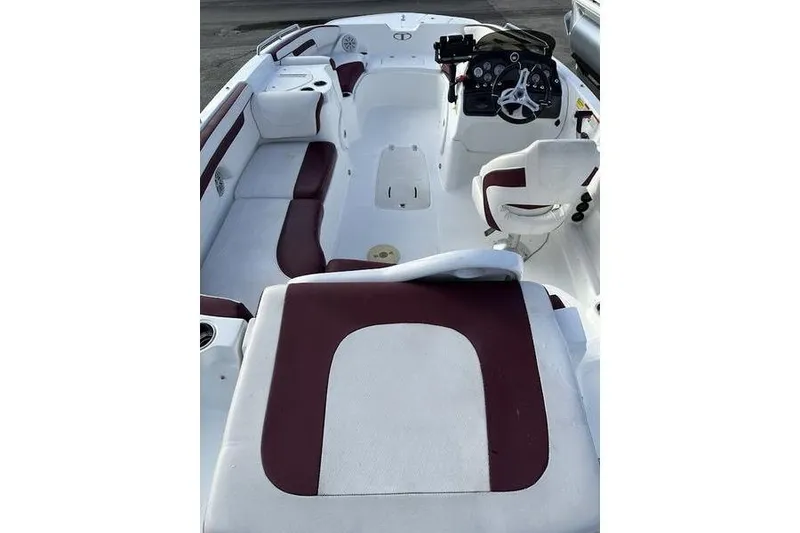 Slide: The Image of 2018 Tahoe 215 Xi boat interior with white and maroon seating, steering console visible. - 21