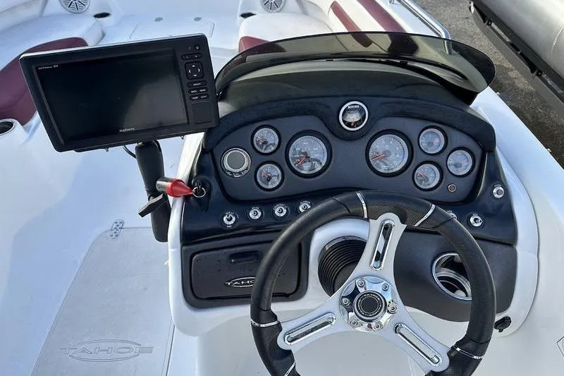 Slide: The Image of 2018 Tahoe 215 Xi boat dashboard with steering wheel and control panel. - 23