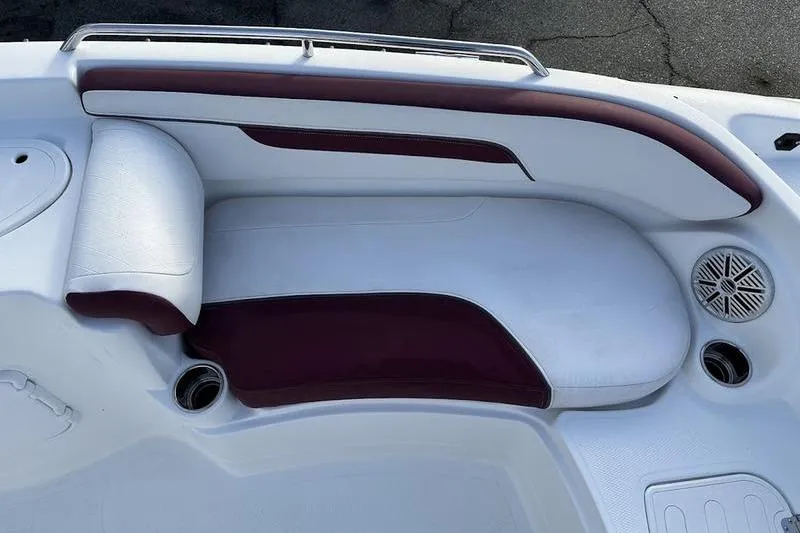 Slide: The Image of 2018 Tahoe 215 Xi boat interior with white and maroon seating, cup holders, and speaker. - 3
