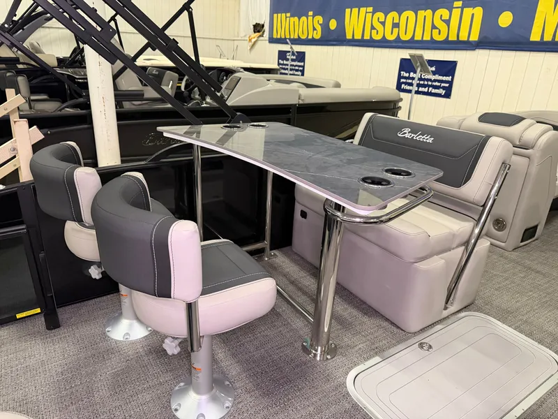 Slide: The Image of The image shows the interior of a 2026 Barletta Cabrio 24 UE. There are cushioned seats and a table. - 31