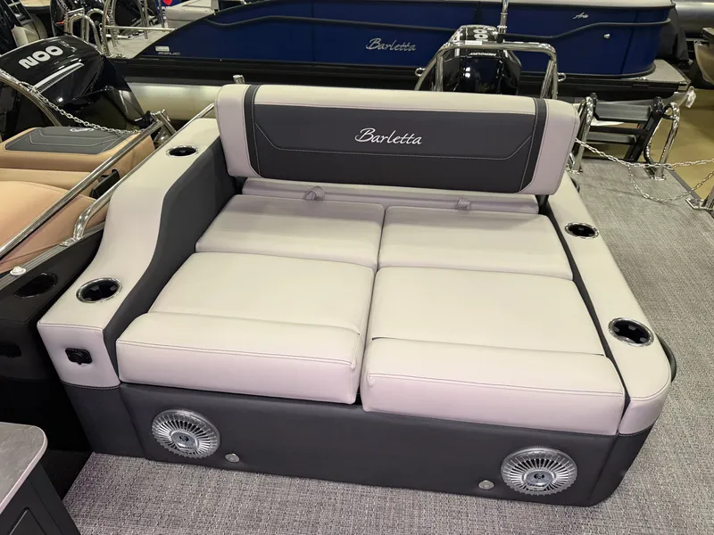 Slide: The Image of The image shows a luxurious seating area on a Barletta Cabrio 24 UE boat, with comfortable cushions and cup holders. - 34