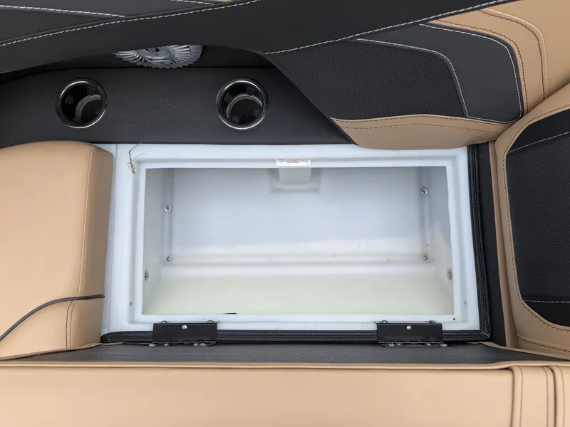 Slide: The Image of An open storage compartment on a Barletta Cabrio 24 QC boat with beige and black upholstery. - 56