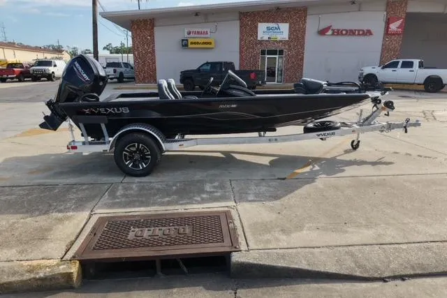 Slide: The Image of 2026 Vexus AVX181 boat on trailer outside dealership with Yamaha and Honda signage. - 2