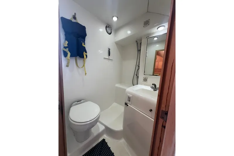 Slide: The Image of Compact bathroom in 2002 Out Island 38 Express Fisherman boat with toilet, sink, and life jacket. - 22