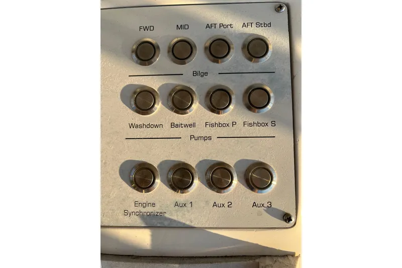 Slide: The Image of Control panel of a 2002 Out Island 38 Express Fisherman boat with labeled buttons. - 38
