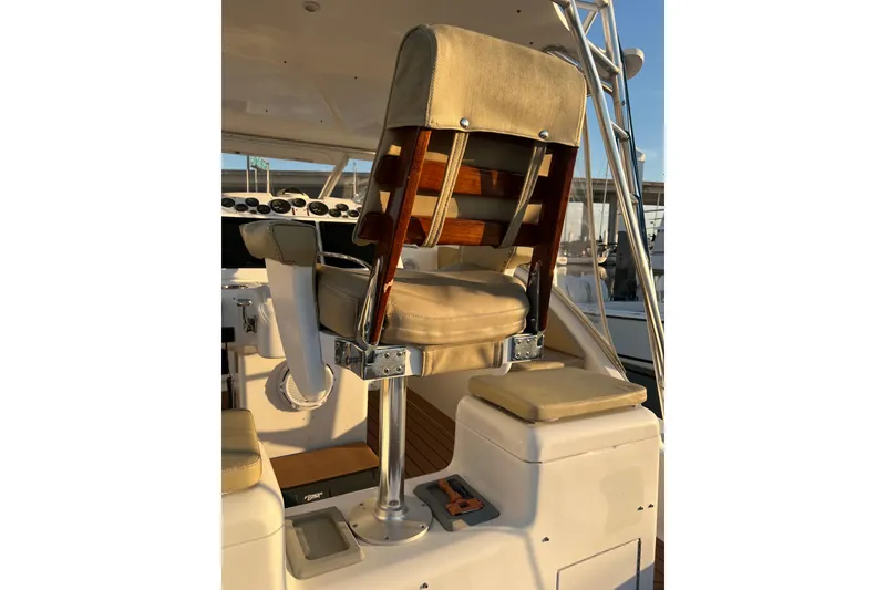 Slide: The Image of Captain's chair on 2002 Out Island 38 Express Fisherman boat, featuring beige upholstery and wooden accents. - 43