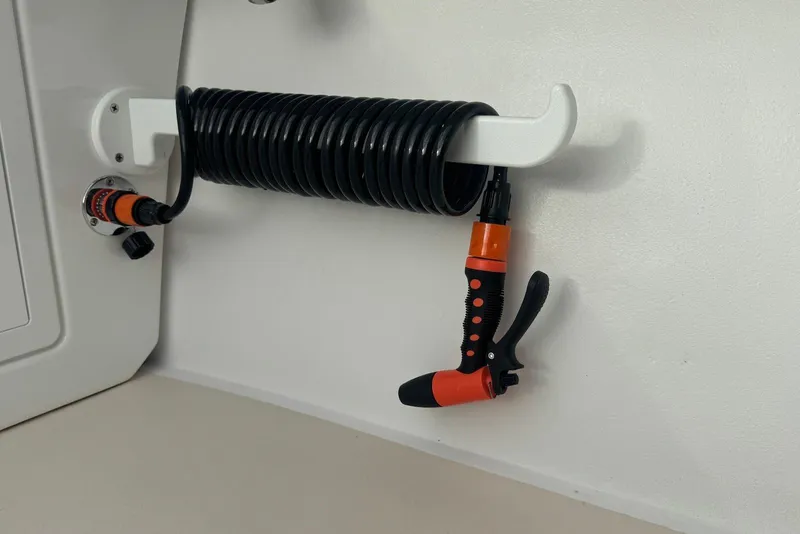 Slide: The Image of Coiled hose and spray nozzle on 2026 Steiger Craft 21 MIAMI boat interior. - 19
