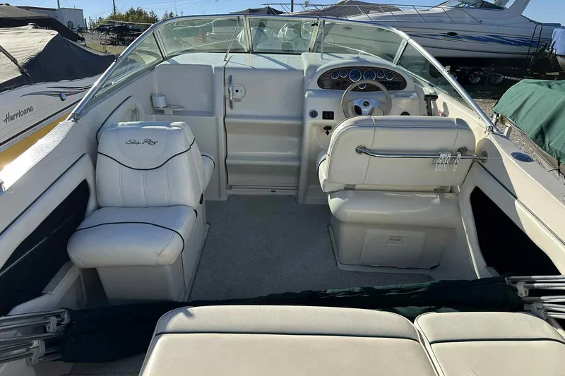 Slide: The Image of 2000 Sea Ray 215 Express Cruiser interior with white seating and dashboard view. - 12