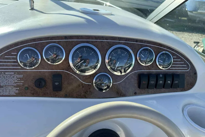 Slide: The Image of Dashboard of a 2000 Sea Ray 215 Express Cruiser with gauges and controls. - 2