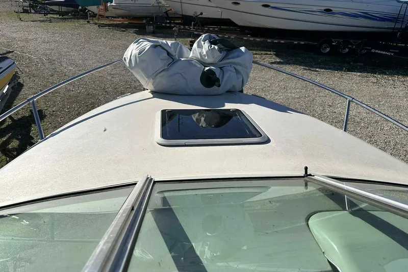 Slide: The Image of 2000 Sea Ray 215 Express Cruiser boat deck with hatch, parked outdoors. - 8