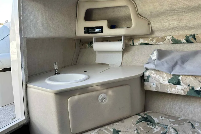 Slide: The Image of Interior of 2000 Sea Ray 215 Express Cruiser with sink and patterned seating. - 9