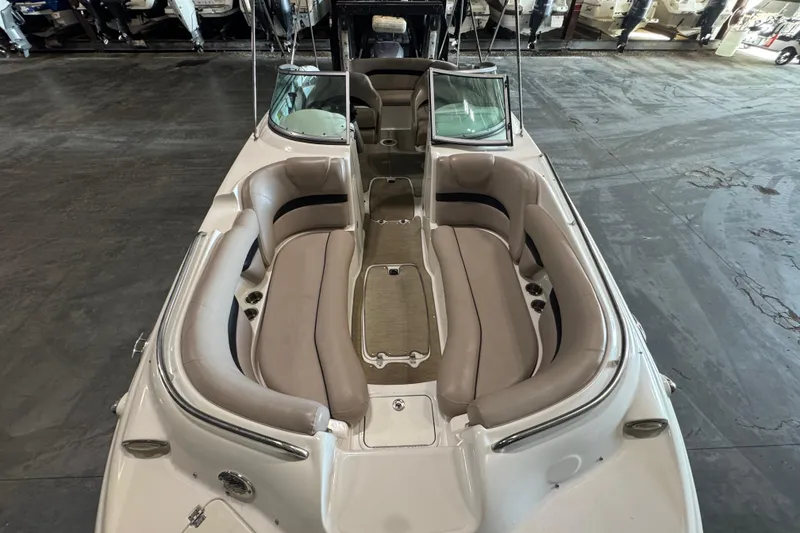 Slide: The Image of 2014 Hurricane SunDeck 2400 OB boat with spacious seating and sleek design in a showroom. - 16