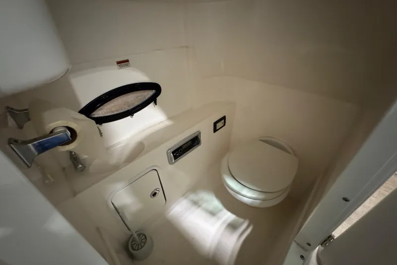 Slide: The Image of 2014 Hurricane SunDeck 2400 OB boat bathroom interior with toilet and small window. - 19
