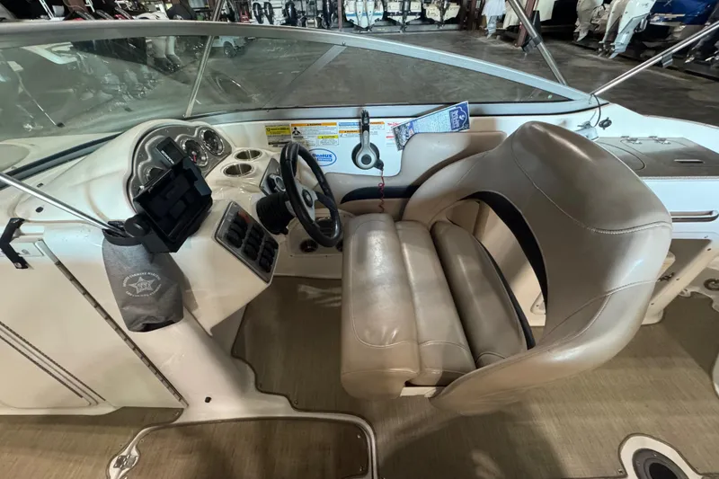Slide: The Image of 2014 Hurricane SunDeck 2400 OB boat cockpit with steering wheel and beige seating. - 21