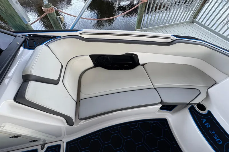 Slide: The Image of 2023 Yamaha Boats AR250 interior seating with sleek white and gray upholstery. - 16