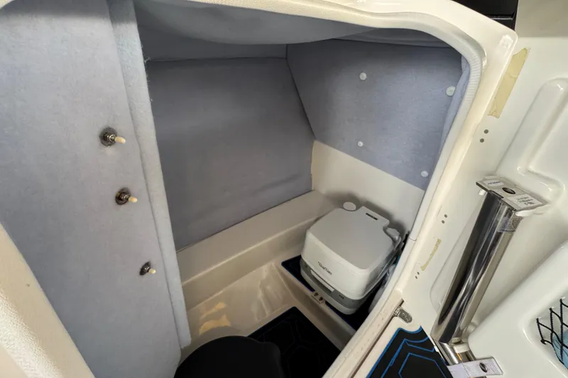 Slide: The Image of 2023 Yamaha AR250 boat interior with compact marine toilet and storage space. - 18