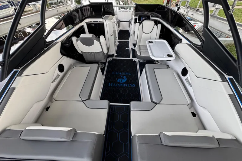 Slide: The Image of 2023 Yamaha Boats AR250 interior with sleek seating and "Chasing Happiness" floor mat. - 22