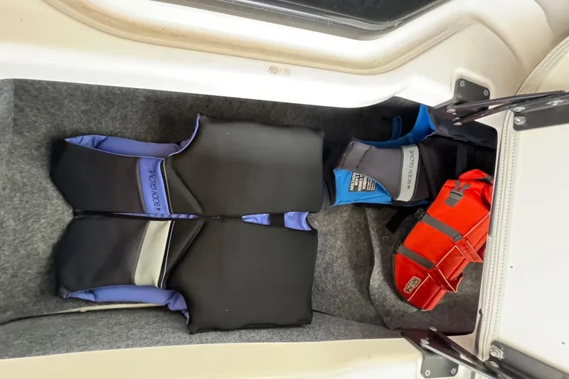 Slide: The Image of Storage compartment in 2023 Yamaha AR250 boat with life jackets and safety gear. - 28