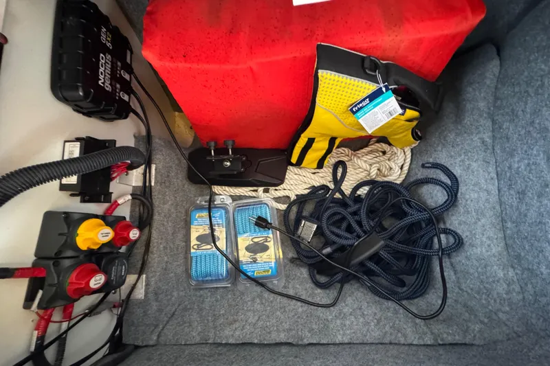 Slide: The Image of Storage compartment of 2023 Yamaha AR250 boat with safety gear and ropes. - 29