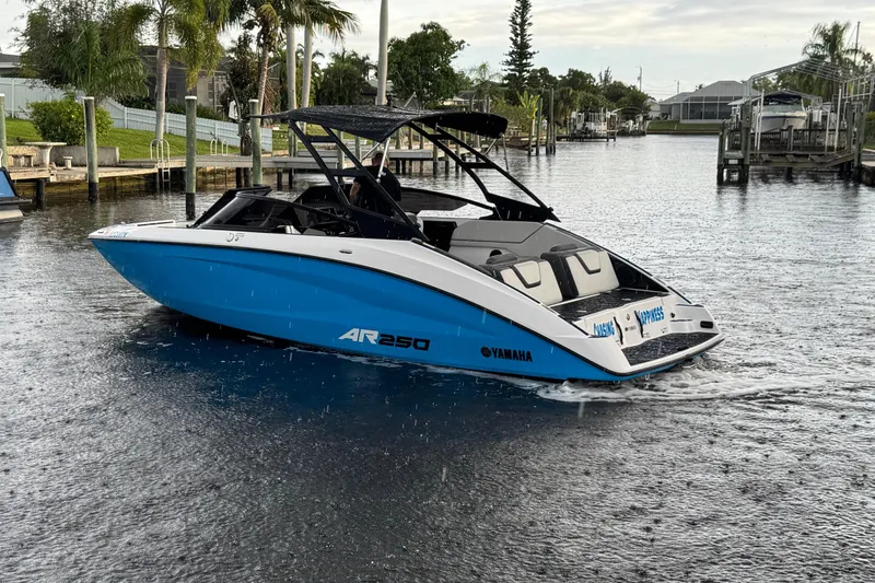 Slide: The Image of 2023 Yamaha Boats AR250 in a serene waterway, showcasing sleek design and vibrant blue color. - 4