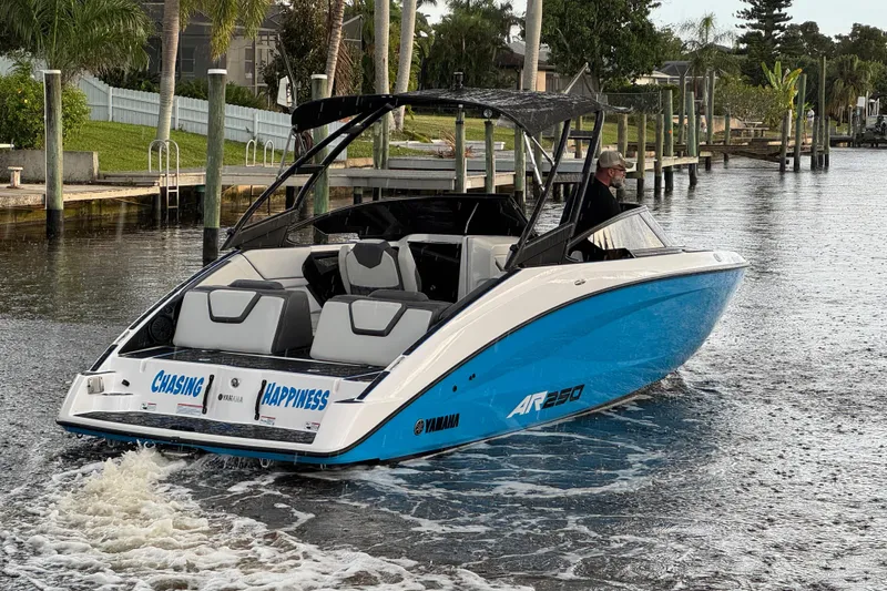 Slide: The Image of 2023 Yamaha AR250 boat cruising on a scenic waterway, featuring sleek design and vibrant blue color. - 5