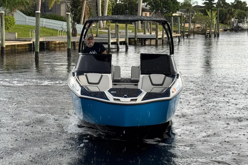 Slide: The Image of 2023 Yamaha Boats AR250 on a calm waterway, showcasing sleek design and modern features. - 8