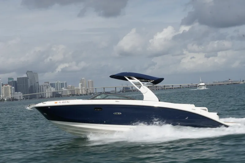 The Image of 2018 Sea Ray SDX 290 cruising on water with city skyline in background. - 0