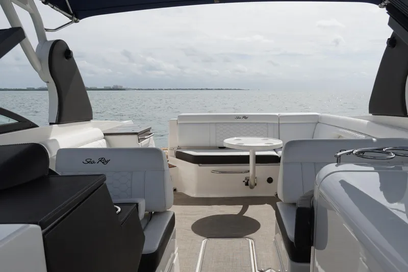 Slide: The Image of 2018 Sea Ray SDX 290 boat interior with seating and table, overlooking calm waters. - 13