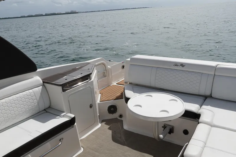 Slide: The Image of 2018 Sea Ray SDX 290 boat interior with white seating and ocean view. - 14
