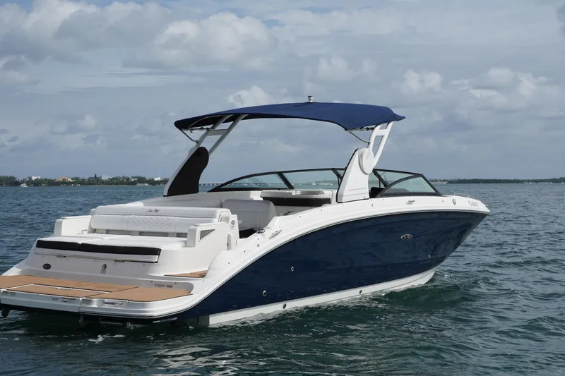 Slide: The Image of 2018 Sea Ray SDX 290 boat on calm water with blue canopy. - 5