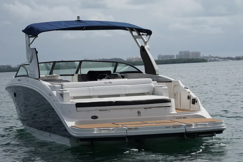 Slide: The Image of 2018 Sea Ray SDX 290 boat with blue canopy on calm water. - 6