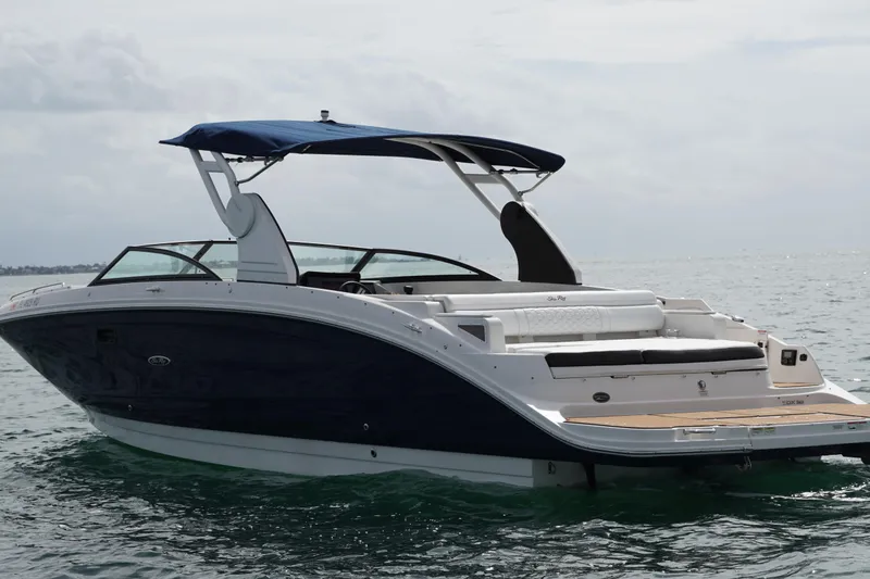 Slide: The Image of 2018 Sea Ray SDX 290 boat with blue hull and canopy on open water. - 7