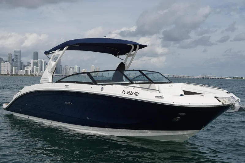 Slide: The Image of 2018 Sea Ray SDX 290 boat cruising near city skyline under cloudy sky. - 8