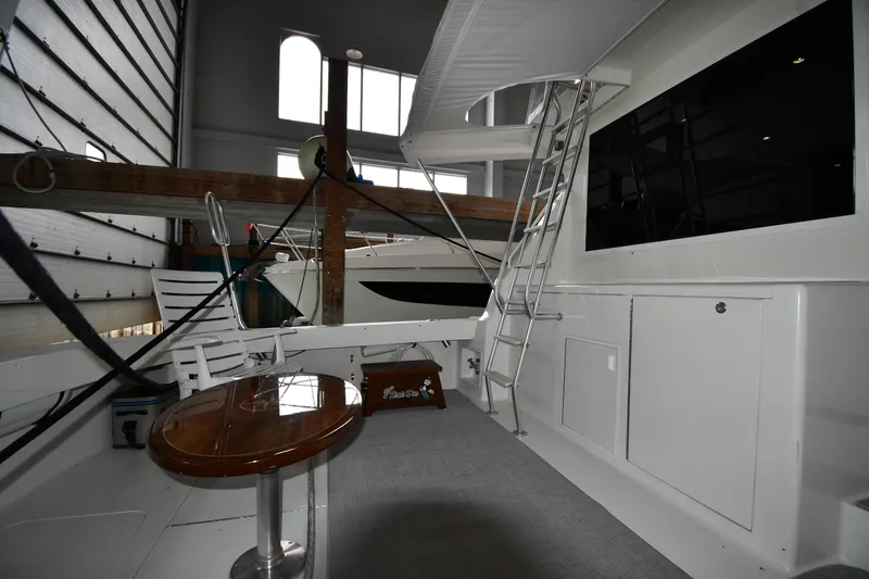 Slide: The Image of 1996 Viking 50 Convertible yacht interior with table, chairs, and ladder in a spacious cabin. - 10