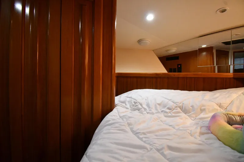 Slide: The Image of Cozy cabin interior of 1996 Viking 50 Convertible yacht with wooden paneling and plush bedding. - 29