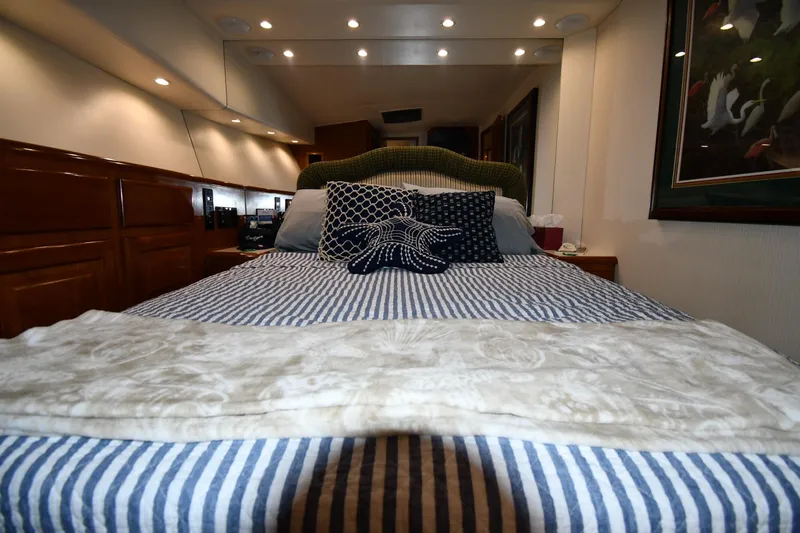 Slide: The Image of Cozy bedroom interior of 1996 Viking 50 Convertible yacht with striped bedding and decorative pillows. - 39