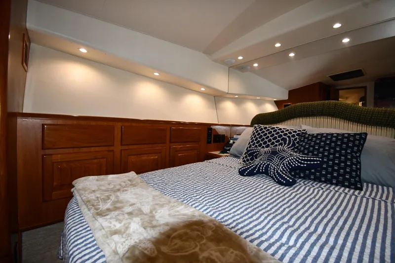 Slide: The Image of Luxurious bedroom interior of 1996 Viking 50 Convertible yacht with striped bedding and decorative pillows. - 41