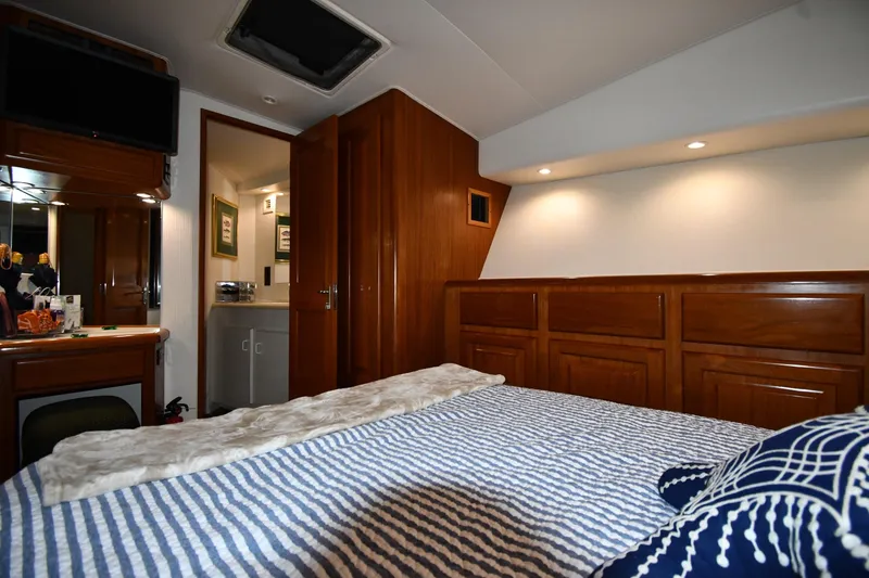 Slide: The Image of Luxurious cabin interior of 1996 Viking 50 Convertible yacht with wood paneling and cozy bedding. - 42