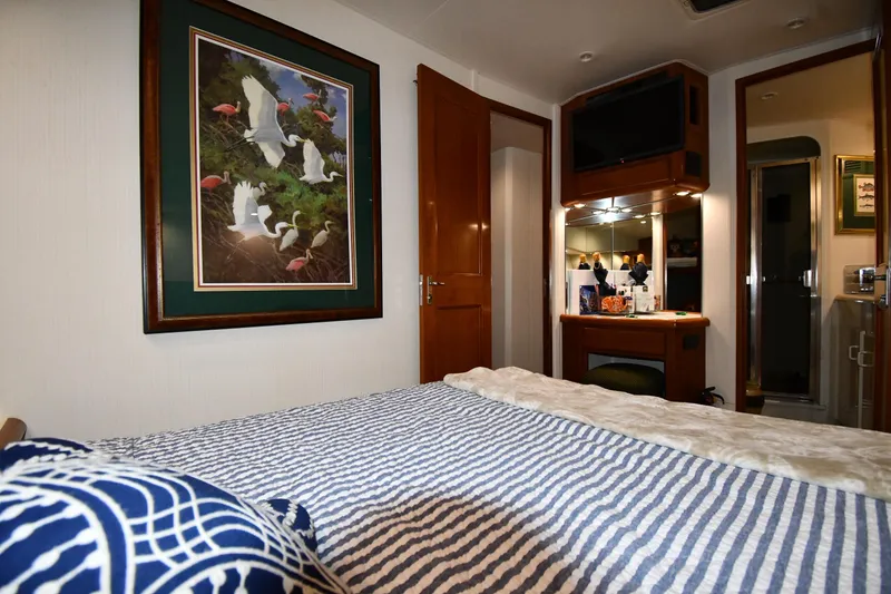Slide: The Image of Bedroom interior of 1996 Viking 50 Convertible yacht with artwork and striped bedding. - 43