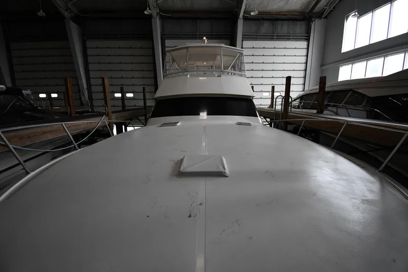 Slide: The Image of 1996 Viking 50 Convertible yacht in storage, viewed from the bow inside a warehouse. - 5